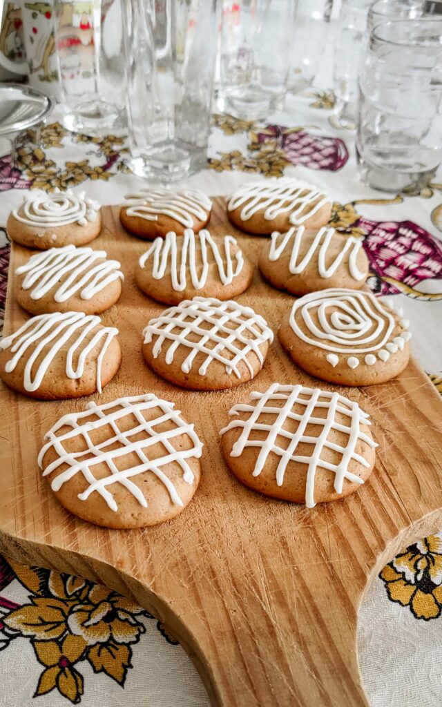 Artfully decorated homemade gingerbread cookies with icing on a wooden board, perfect for holiday gatherings.
